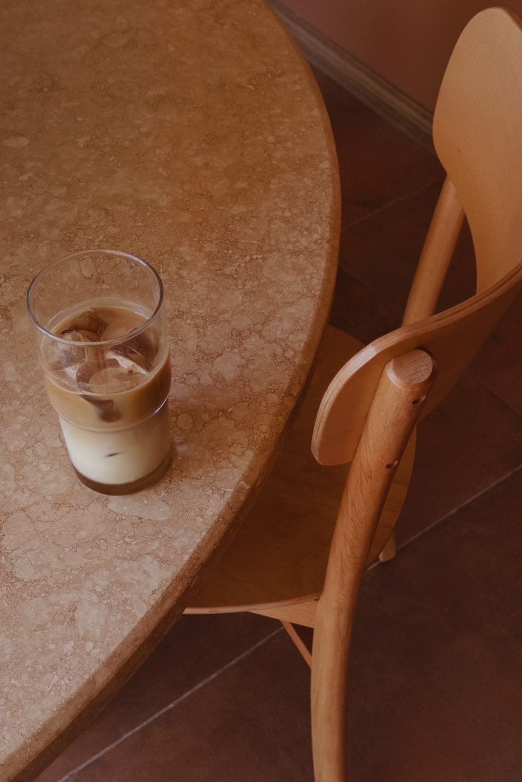 Üstten görünüm: mermer masada buzlu latte ve ahşap sandalye