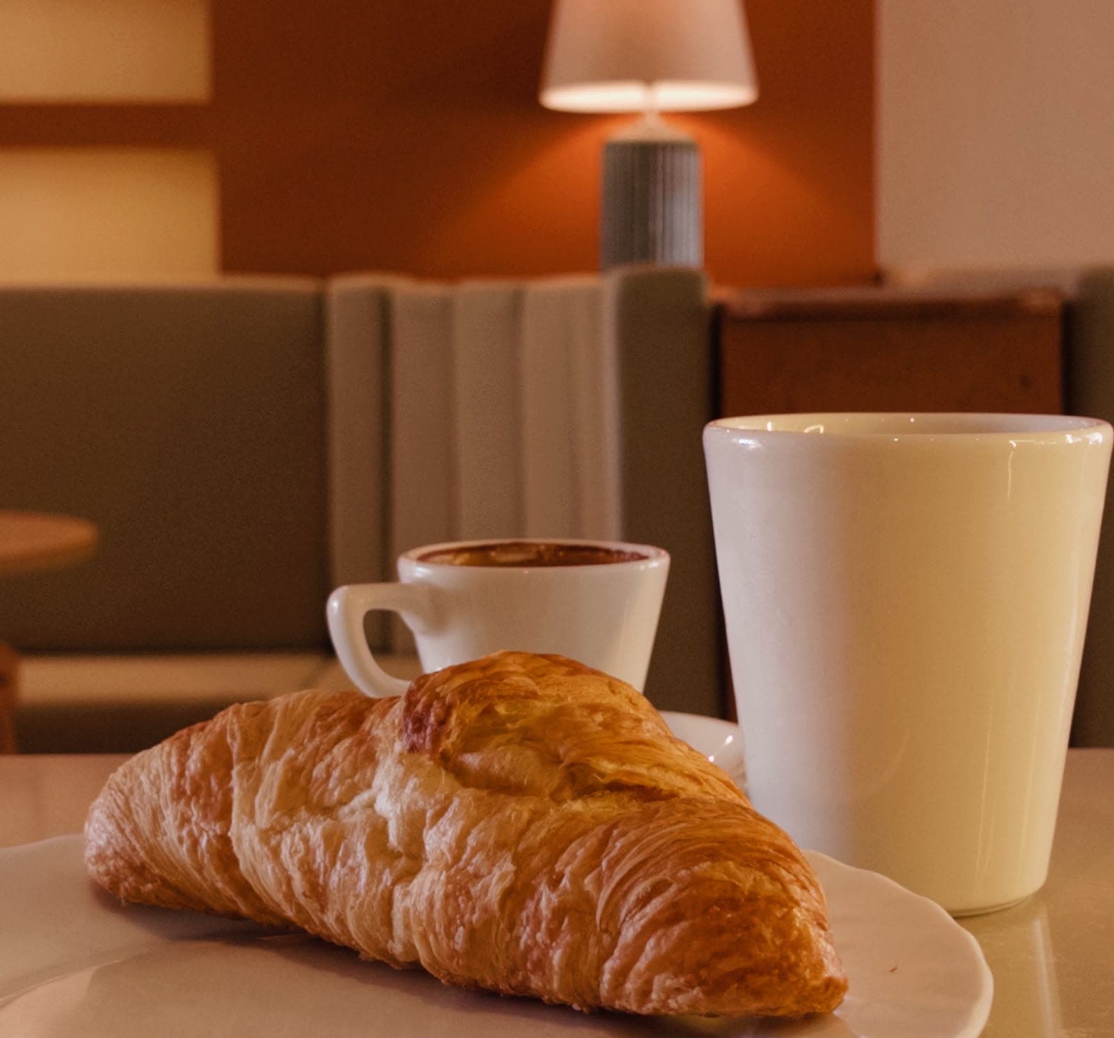 Tabakta taze kruvasan, yanında Türk kahvesi ve latte