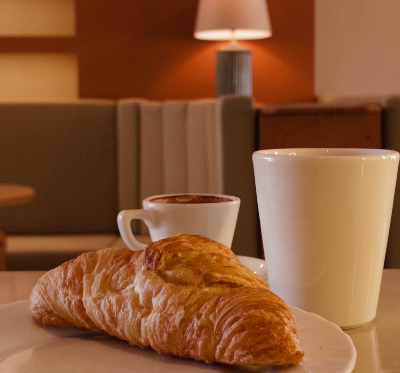 Tabakta taze kruvasan, yanında Türk kahvesi ve latte